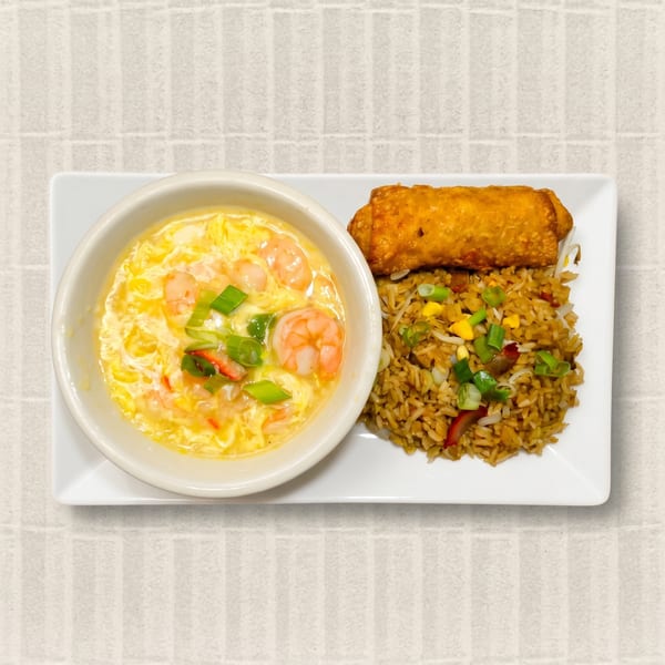 Shrimp egg drop soup, fried rice with vegetables, and an egg roll on a white rectangular plate.