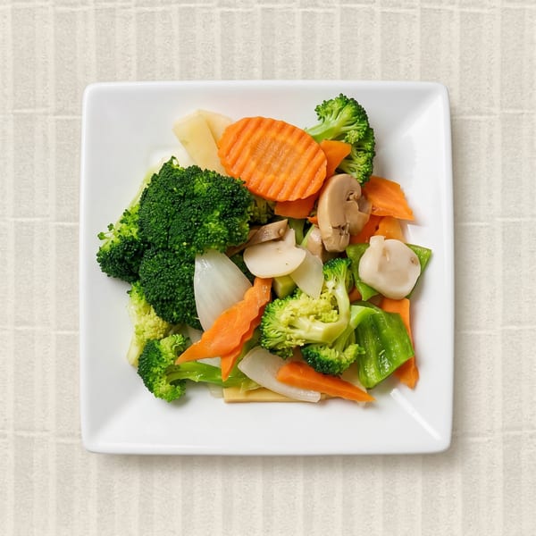 A white square plate filled with colorful steamed vegetables, including broccoli, carrots, mushrooms, and onions.